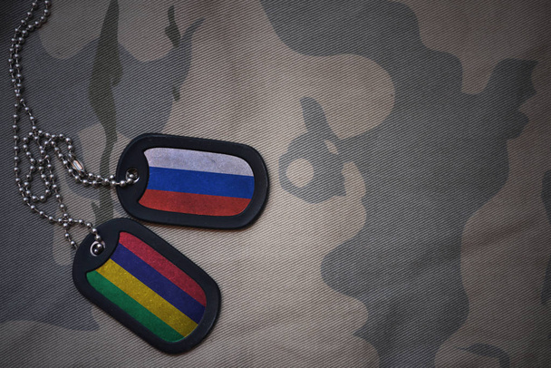 Armee leer, Hundeanhänger mit der Flagge Russlands und mauritius auf dem khakifarbenen Hintergrund. Militärisches Konzept - Foto, Bild