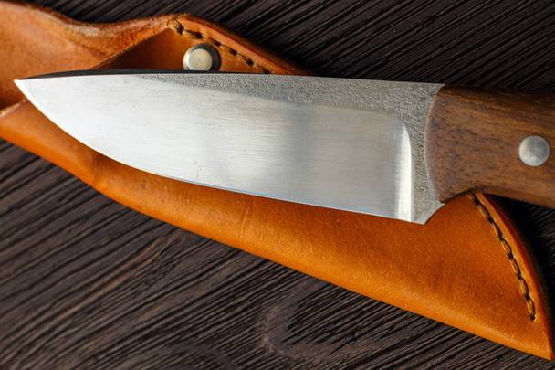 Hunting knifelying on wooden board, top view - Foto, Imagen