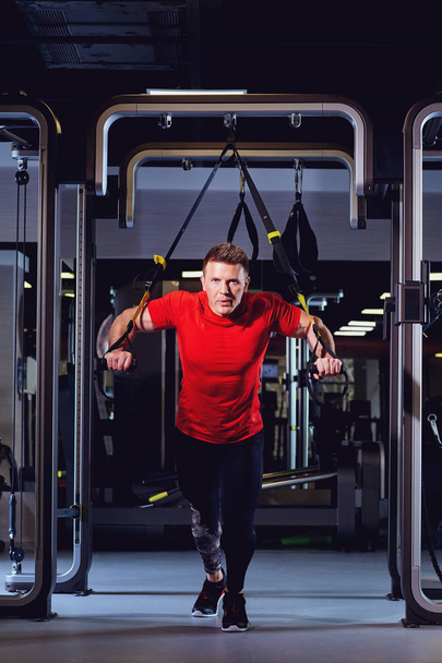 Un hombre está haciendo ejercicios en el simulador en el gimnasio
 - Foto, imagen