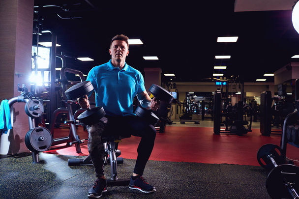 Muscular man with dumbbells in the gym - Φωτογραφία, εικόνα