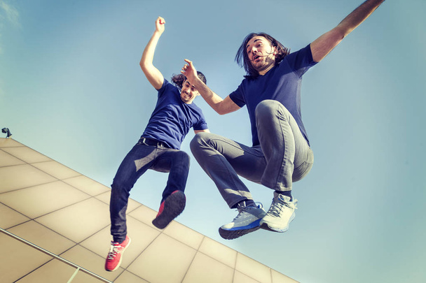 happy young adults jumping on a terrace - Fotó, kép