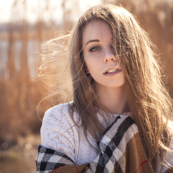 Beautiful young teenage caucasian woman in a plaid walking think - 写真・画像
