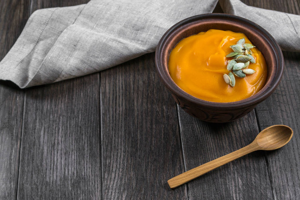 Гарбузовий вершковий суп з насінням у глиняній мисці
  - Фото, зображення