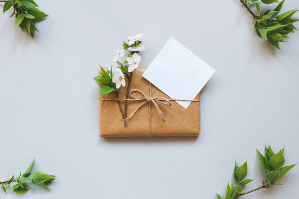 Mignon coffret cadeau enveloppé de papier artisanal et de fleurs vue de dessus
 - Photo, image