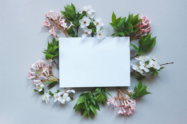 Spring background with paper sheet. Beautiful fresh flowers and  - Фото, зображення