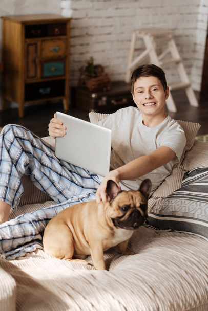 Delighted teenager posing on camera with his pet - Valokuva, kuva