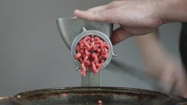 Közelkép a frissen darált hús jön ki egy húsdaráló. - Felvétel, videó
