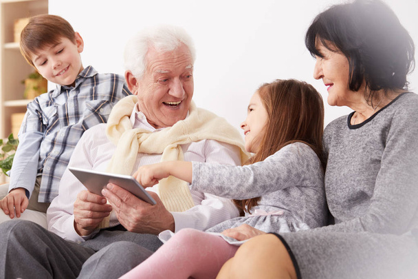 netos e avós usando um tablet
 - Foto, Imagem