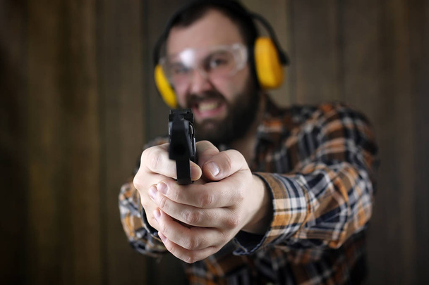 hombre con gafas protectoras y entrenamiento de orejas en pistola sh
 - Foto, Imagen