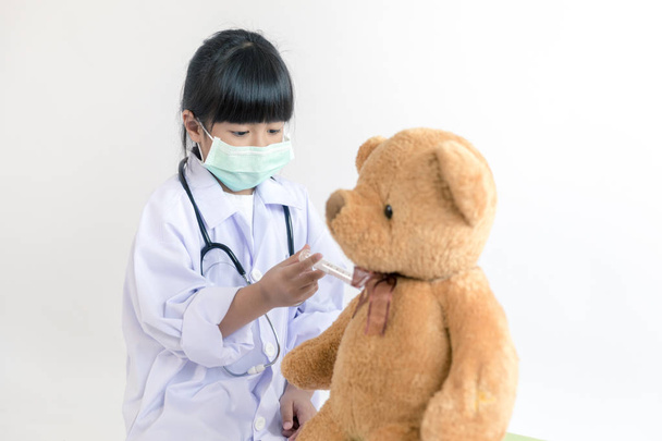 Kind spielt Arzt mit Stethoskop und Teddybär  - Foto, Bild