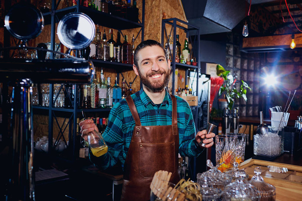 The bartender laughs making a cocktail at the bar - Fotografie, Obrázek