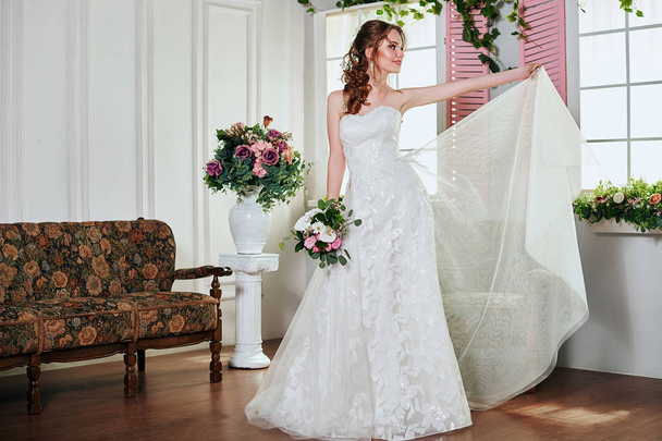 Young attractive bride with flowers - Фото, изображение