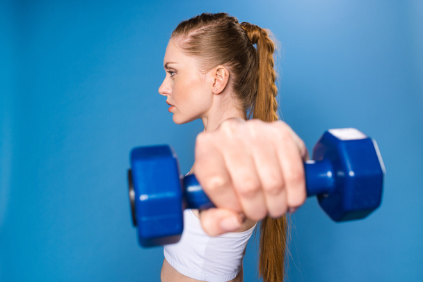 sportswoman training with dumbbell - Фото, изображение