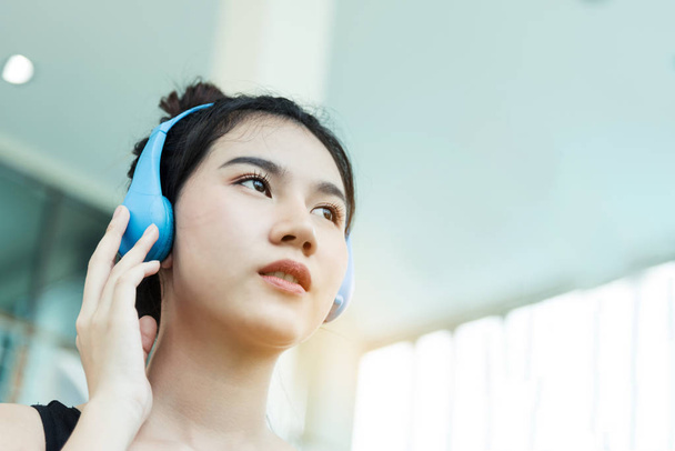 Close up Young Asian girl with blue headphone at the gym. copy s - Foto, Imagen