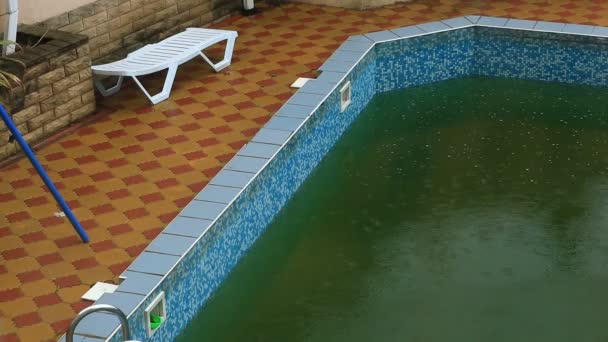 Una forte pioggia cade in una piscina. Non stagione, piscina sporca abbandonata
 - Filmati, video