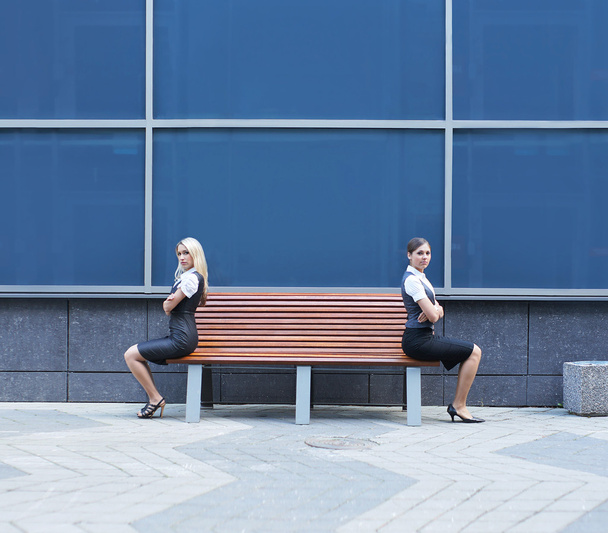 Quarrel between two business women sitting on the bench - 写真・画像