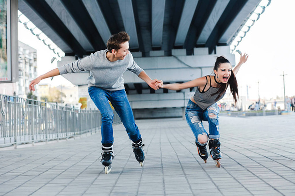 Beautiful sweet couple riding on roller skates - Fotó, kép