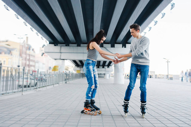 Beautiful sweet couple riding on roller skates - Photo, Image