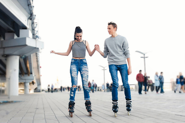 Beautiful sweet couple riding on roller skates - Foto, afbeelding
