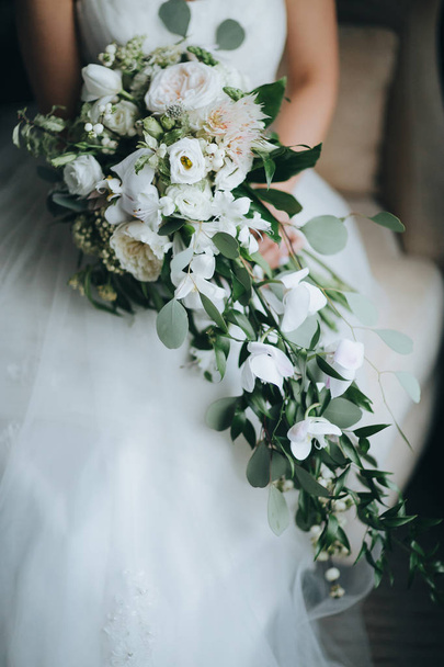 La novia tiene el ramo de boda en las manos
 - Foto, Imagen