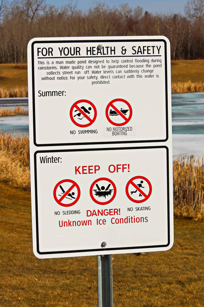 Señales de advertencia alrededor del estanque de drenaje de tormenta
 - Foto, imagen