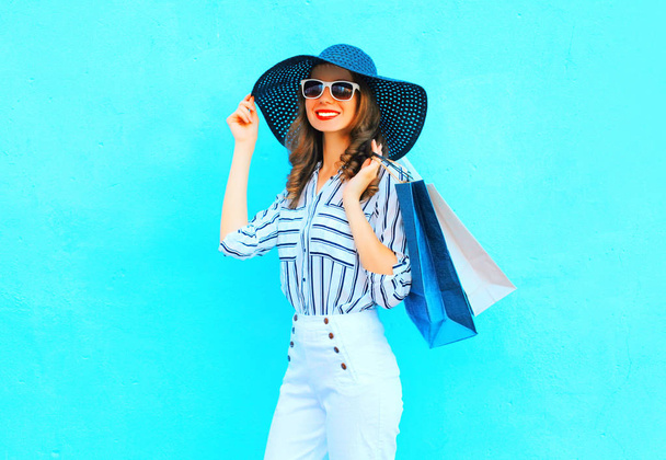 Fashion young smiling woman wearing a shopping bags, straw hat,  - Fotó, kép