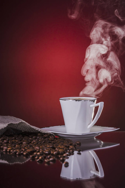 a cup of hot steaming coffee on gradient red background - Foto, Imagem