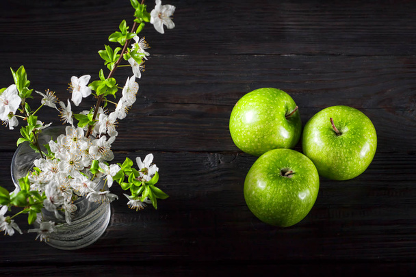 Green apples with blossoms on wooden table - Φωτογραφία, εικόνα