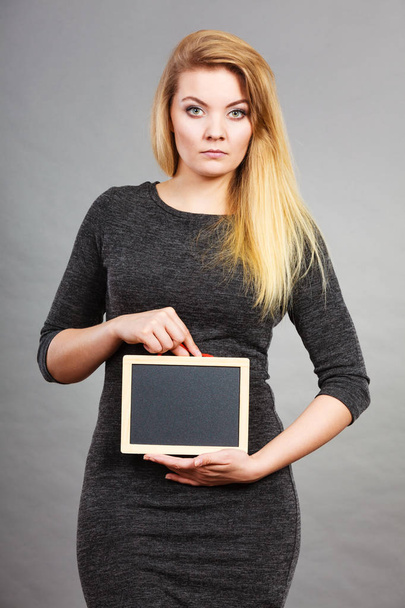 Woman holding blank black board on stomach - Foto, immagini