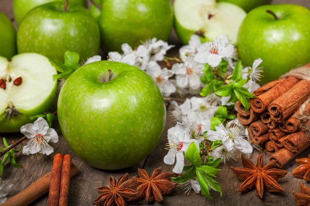 grüne Äpfel, Zimt auf einem hölzernen Hintergrund - Foto, Bild