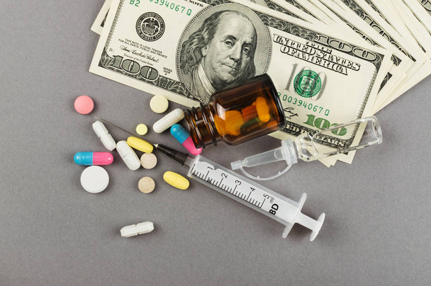 Mnoho pilulek a peníze na šedém pozadí - Fotografie, Obrázek
