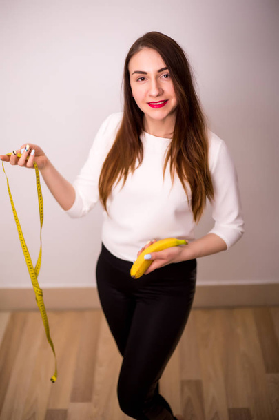 beautiful sporty woman with green apple and measuring tape - Фото, изображение