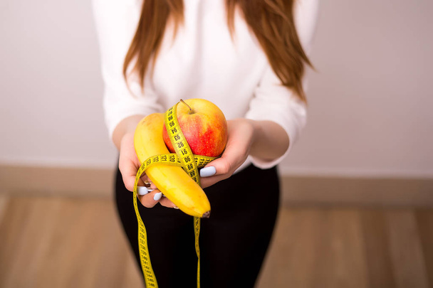beautiful sporty woman with green apple and measuring tape - Fotografie, Obrázek