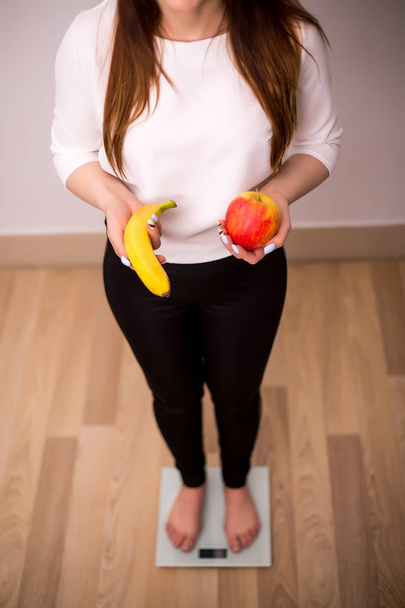 Smiling fit woman with scale and apple - Photo, Image