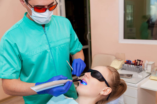 Dentista trabajando con lámpara ultravioleta
 - Foto, imagen