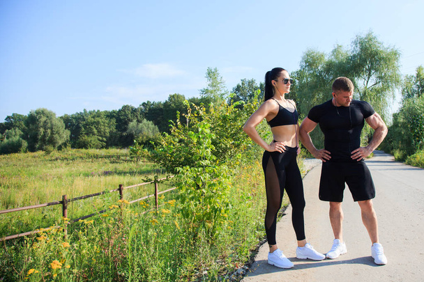 Couple of strong fit man and woman workout outdoors - Photo, Image