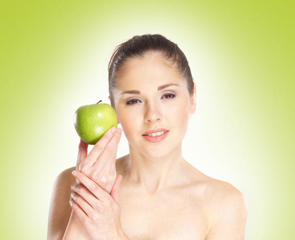 Young sporty girl with the apple over green - Photo, image