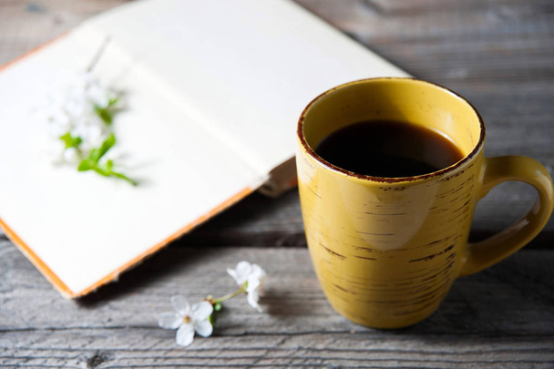 copertina del libro bianco su fondo di legno con fiore primaverile e mantello di caffè
 - Foto, immagini