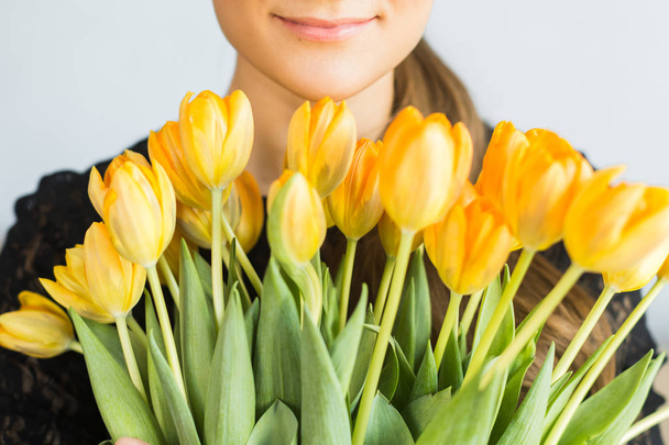 Girl with big bouquets of yellow tulips - Photo, image
