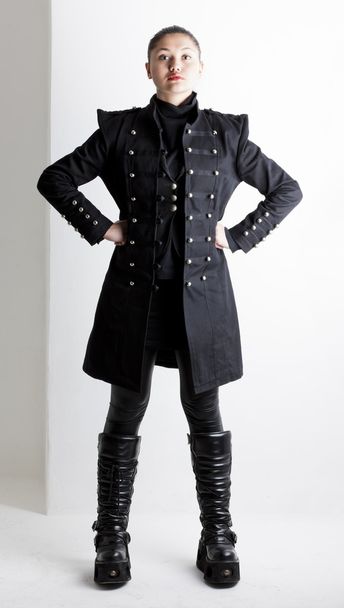 staande vrouw dragen extravagante kleren en laarzen - Foto, afbeelding