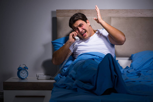 Mladý muž zápasí s hlukem v posteli - Fotografie, Obrázek