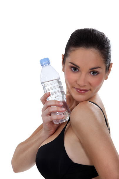 Woman in black bra holding bottle of water - Фото, зображення