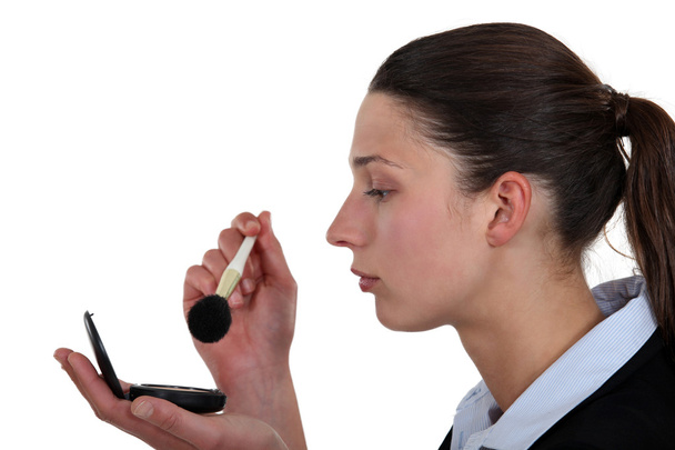 Businesswoman putting on makeup - Foto, Bild