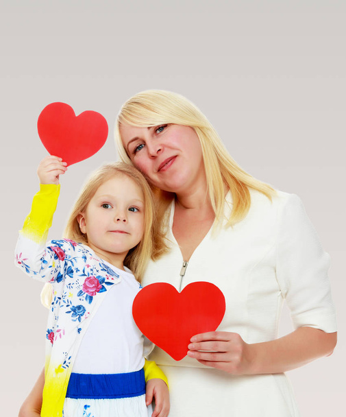 Mother and daughter holding a heart. - Фото, зображення