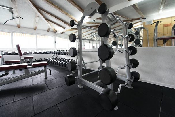 Apparatuur en machines in het moderne fitnesscentrum van de fitnessruimte - Foto, afbeelding