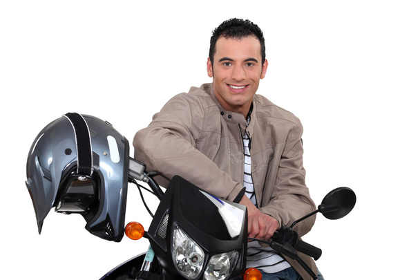 Smiling man sitting on a motorbike - Photo, image