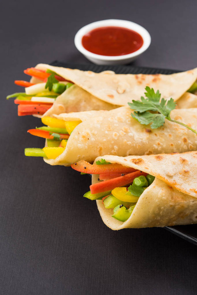 Indian popular snack food called Vegetable spring rolls or veg franky made using vegetables wrapped inside paratha/chapati/roti with tomato ketchup - Photo, Image