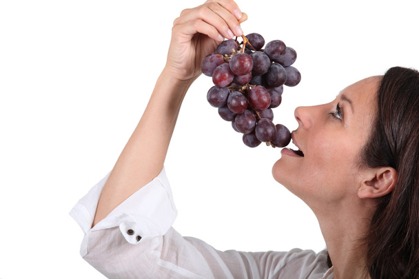 Donna che mangia un grappolo d'uva
 - Foto, immagini