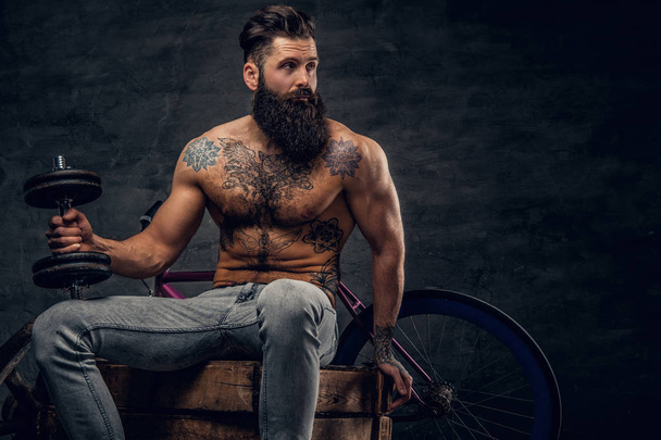 Без сорочки бородатий чоловік з татуйованим торсом
 - Фото, зображення