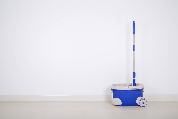 mop and blue bucket on floor and wall background - Foto, Imagen
